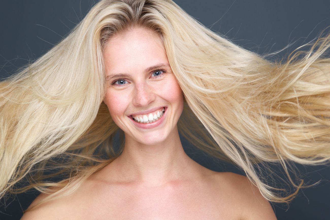 Close up portrait of a joyful young blond woman with beautiful hair